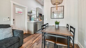 A modern kitchen with grey cabinets, a microwave, and a sink. - Surf Shack Tiny Home on Pinellas Trail w/ Heated Pool! Walk or Bike to Downtown Dunedin! (Dunedin)