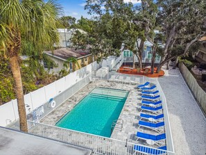 Relax by the pool surrounded by lush greenery and comfortable lounge chairs.