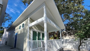 Ein zweistöckiges Haus mit Veranda und kleiner Terrasse.