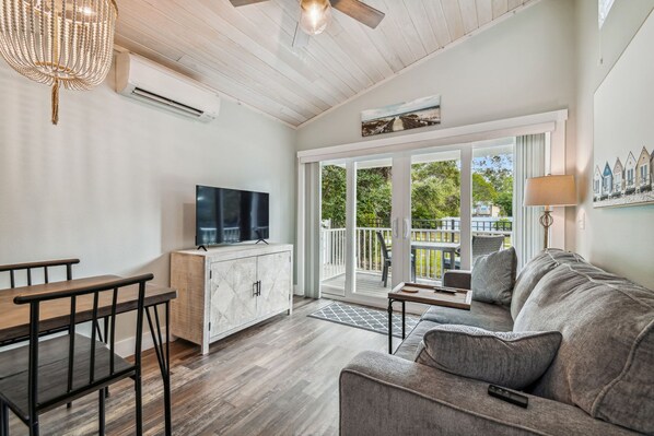 Relax in this stylish living room with a large flat-screen TV, sofa, and dining table.