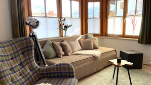 A living room with a sofa, a small table, and a tripod lamp.