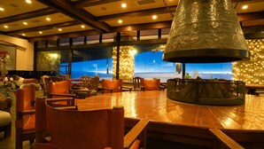A restaurant with a large wooden table, chairs, and a hanging light fixture. - Hotel Onikoube (Osaki)