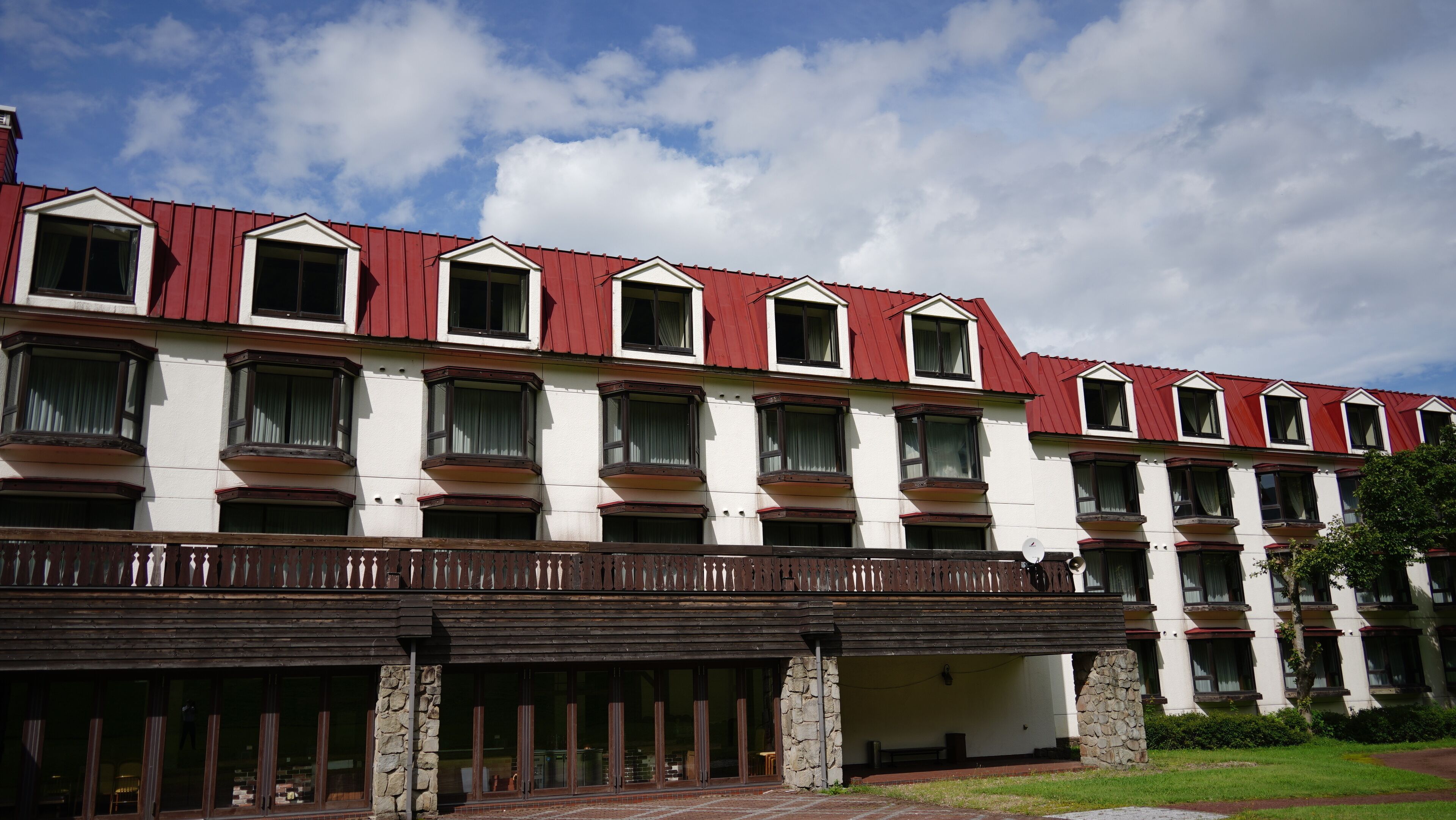 Um hotel com vários andares, teto vermelho, paredes brancas e varandas.