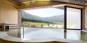 Zona de spa con un amplio ventanal que ofrece vistas a un paisaje montañoso.