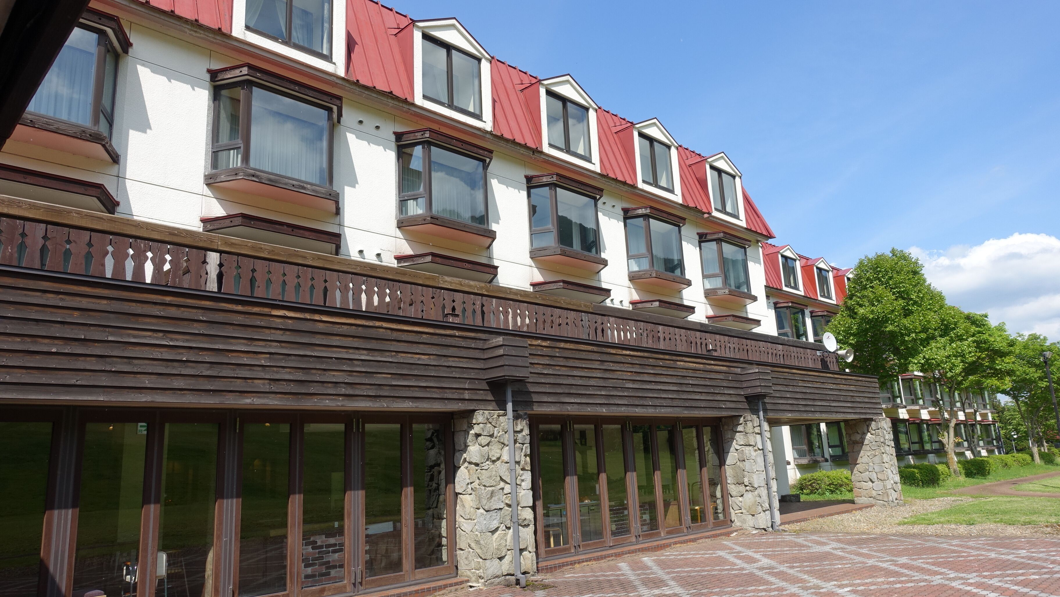 A multi-story hotel with balconies, large windows, and a stone facade.