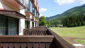 A hotel with a wooden deck and a mountain view. - Hotel Onikoube (Osaki)