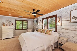 A bedroom with a bed, dresser, nightstand, and a ceiling fan. - McWonderful Manor by Destination Big Bear: Walking Distance to Snow Summit! Spa! Fire Table! Central A/C! Arcade Games! (Big Bear Lake)