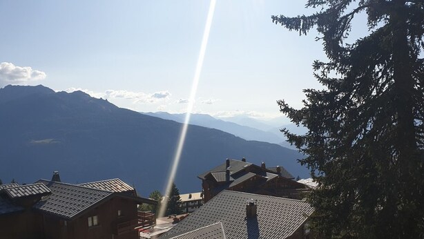 A village with traditional wooden buildings, a clear sky, and mountains in the background. - Cozy studio near slopes with WIFI (Montvalezan-La Rosière)