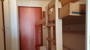 A narrow hallway with bunk beds on one side and a door at the end. - Cozy studio near slopes with WIFI (Montvalezan-La Rosière)