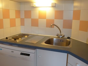 A kitchen with a dishwasher, a stove, and a sink.