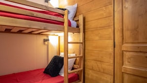 Una litera con un colchón rojo y una escalera de madera.
