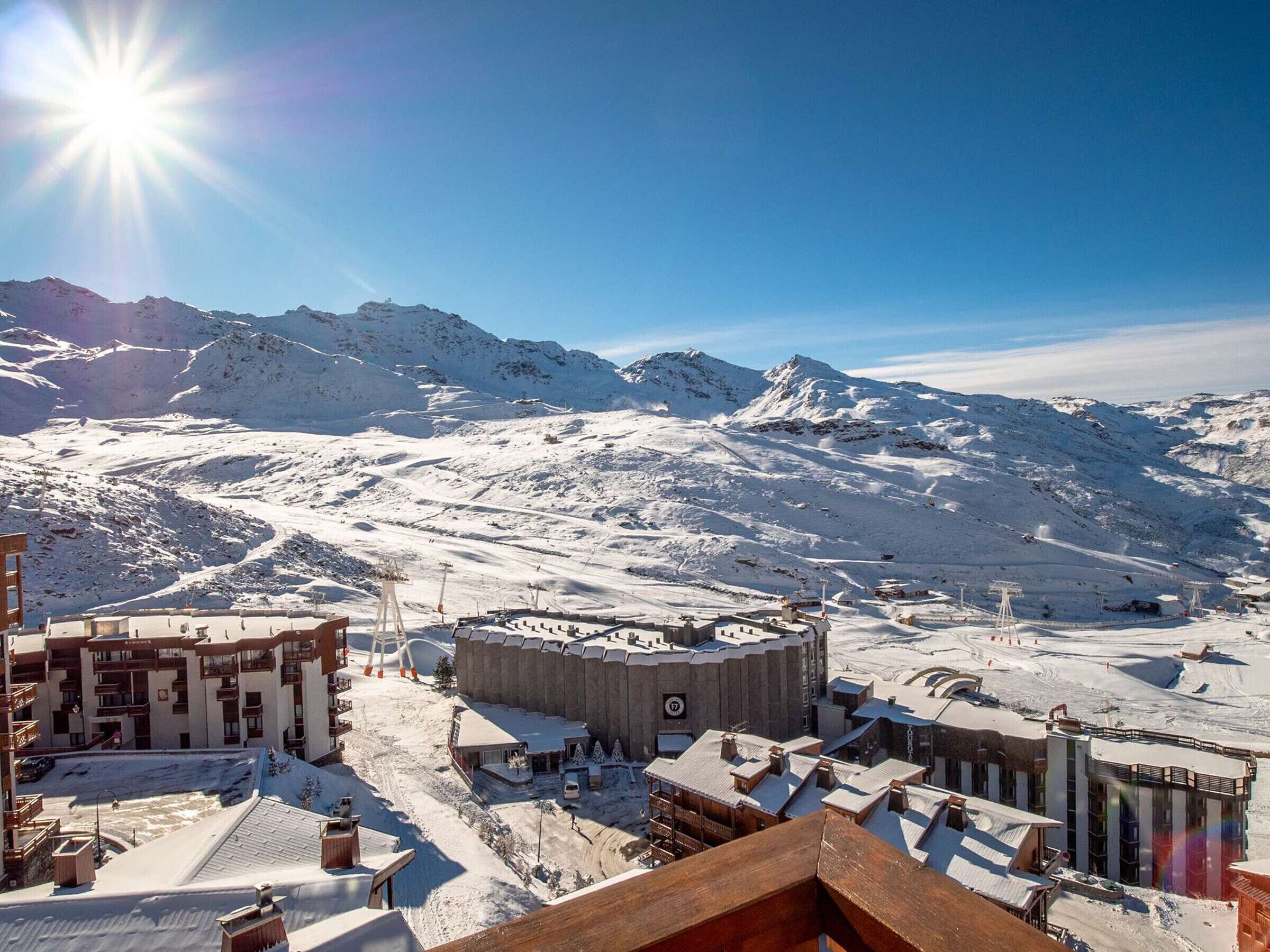 A snow-covered mountain town with buildings and a ski slope.