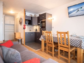 A compact living space with a kitchenette, dining area, and a sofa. - Val Thorens - Apartment for 6, 3 Gold Flakes, 2 baths, near ski lifts (Val Thorens)