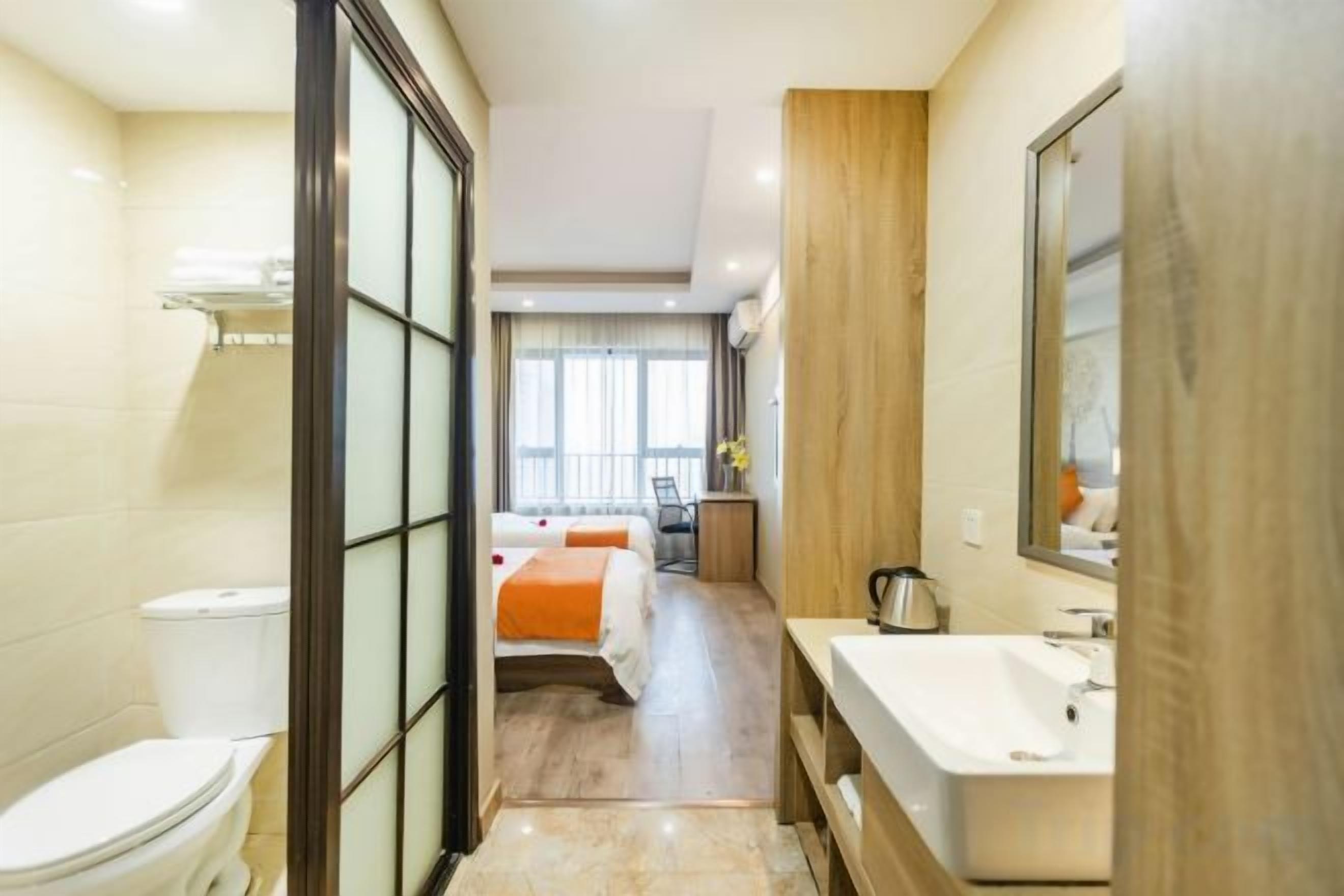 Baño de hotel con inodoro, lavamanos y zona de ducha.