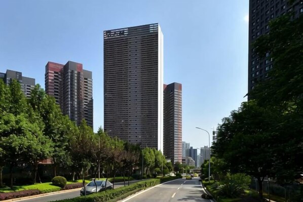 A city street lined with tall buildings, trees, and a clear sky. - Zhigu Yashe Hotel (Chongqing)