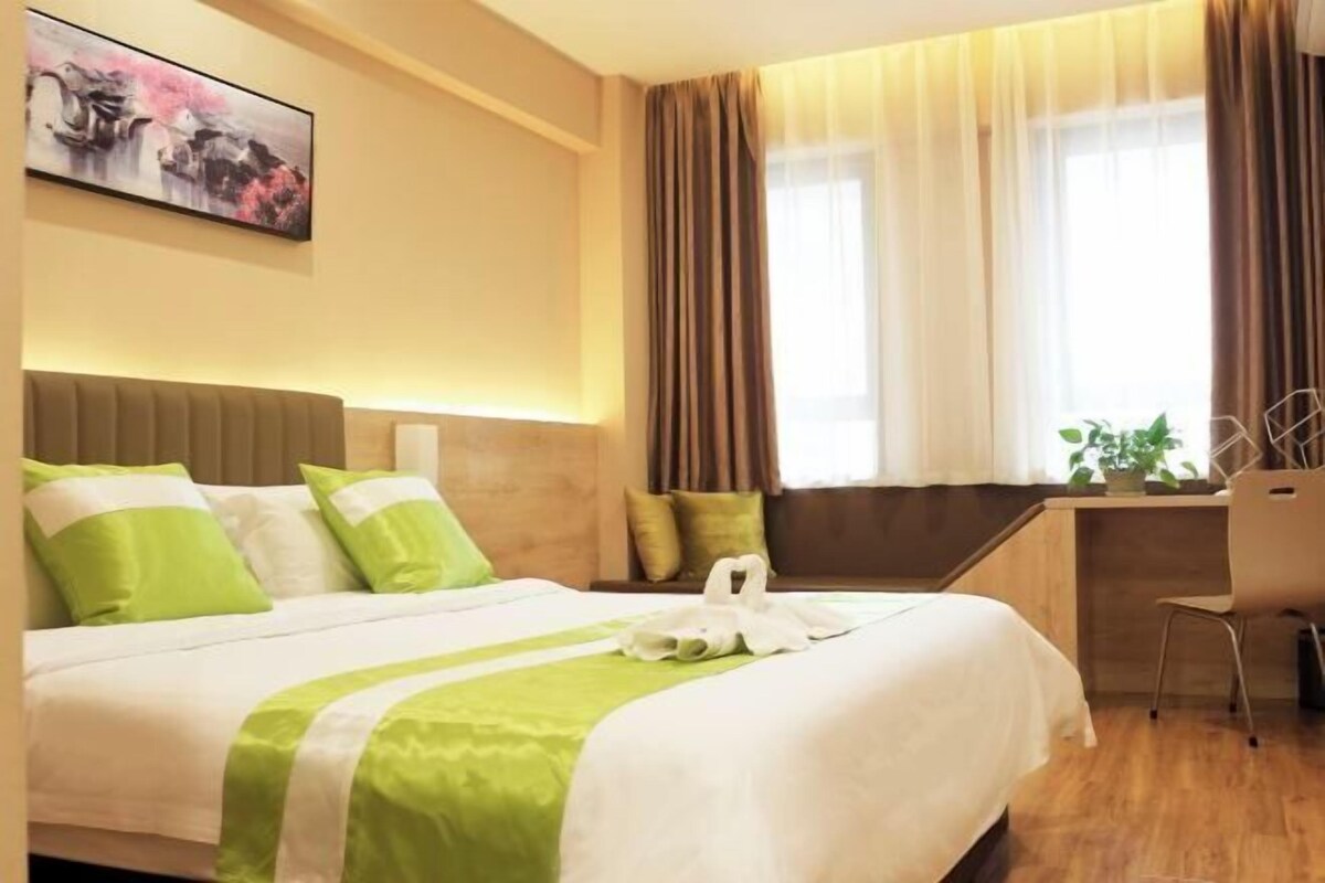A hotel room with a bed, a desk, and a chair.