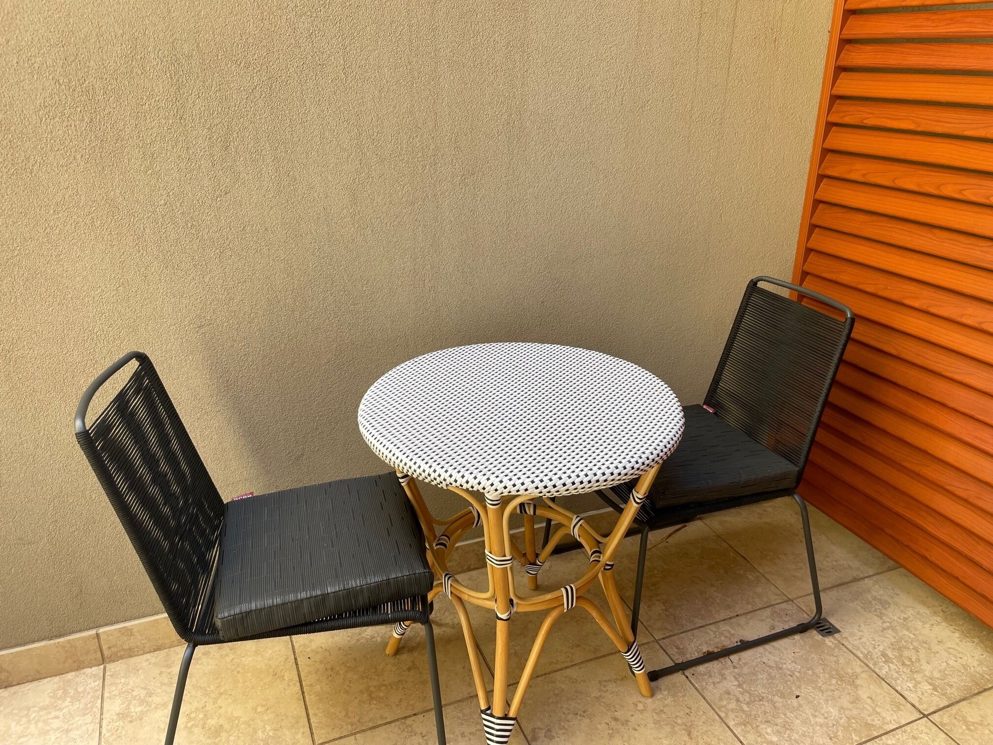Un petit espace extérieur aménagé avec une table ronde et deux chaises.
