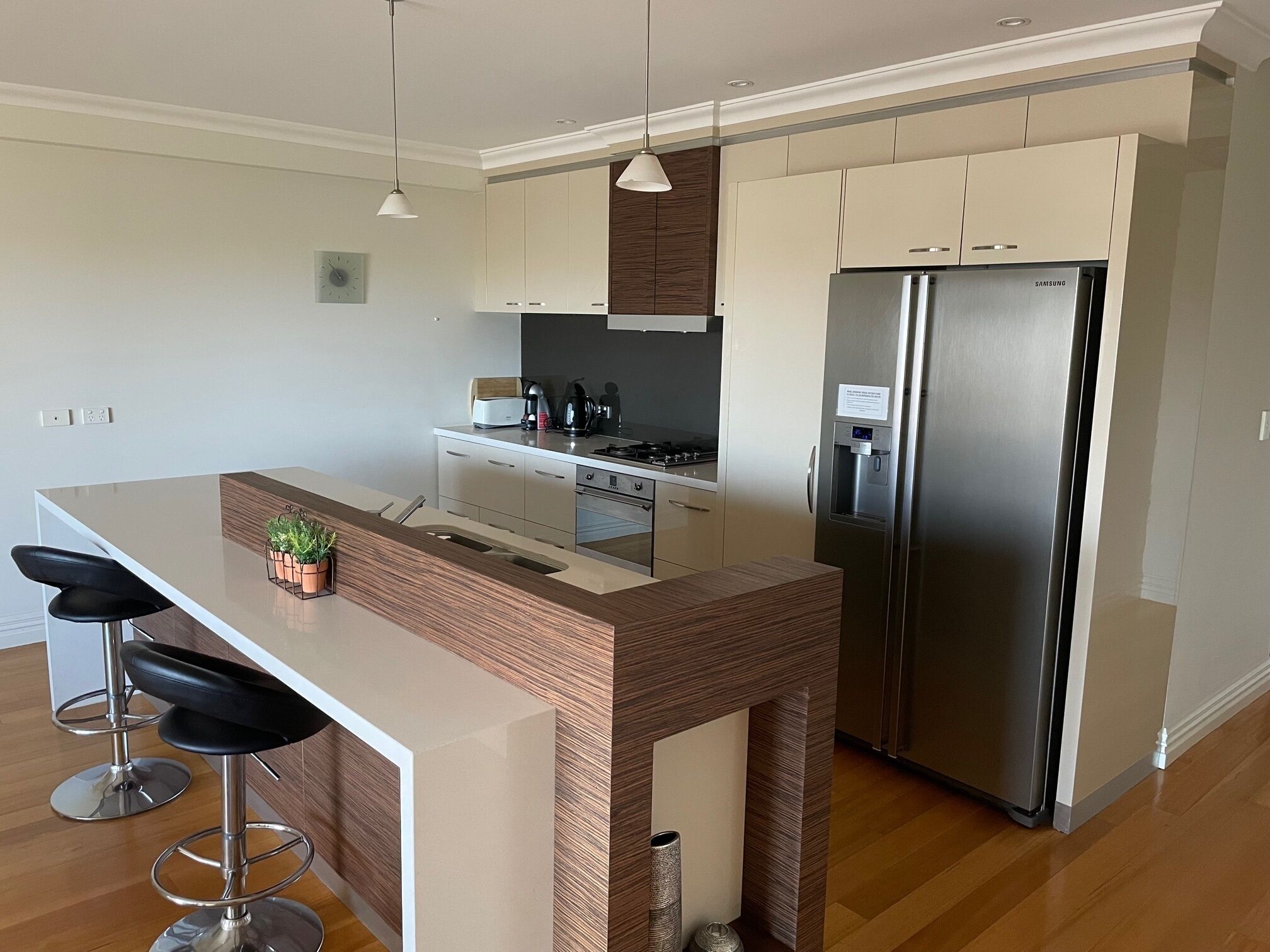 A modern kitchen with a central island, stainless steel appliances, and a minimalist design.