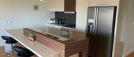 A modern kitchen with a central island, stainless steel appliances, and a minimalist design.