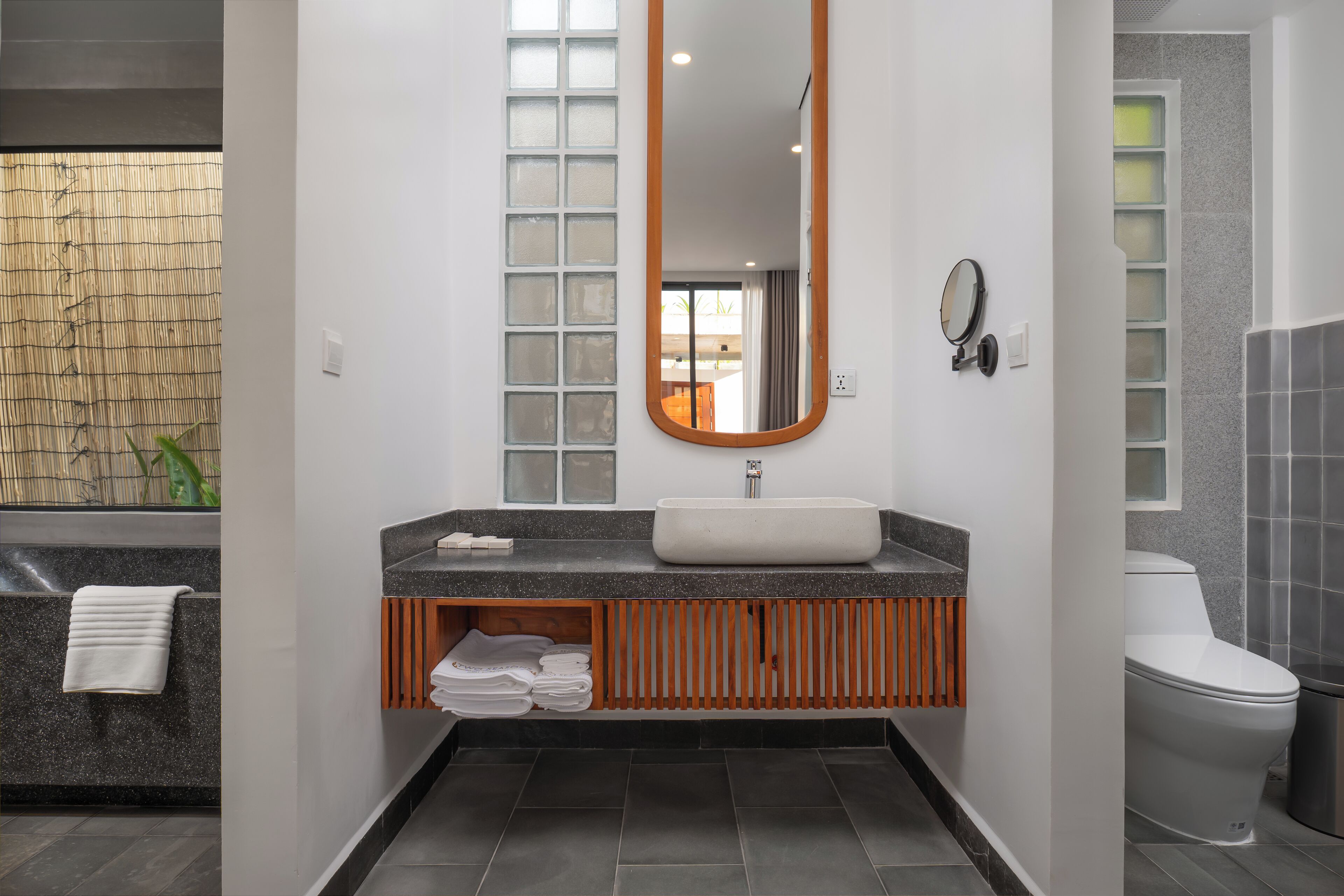 Une salle de bain moderne avec un grand miroir, un lavabo et des toilettes.