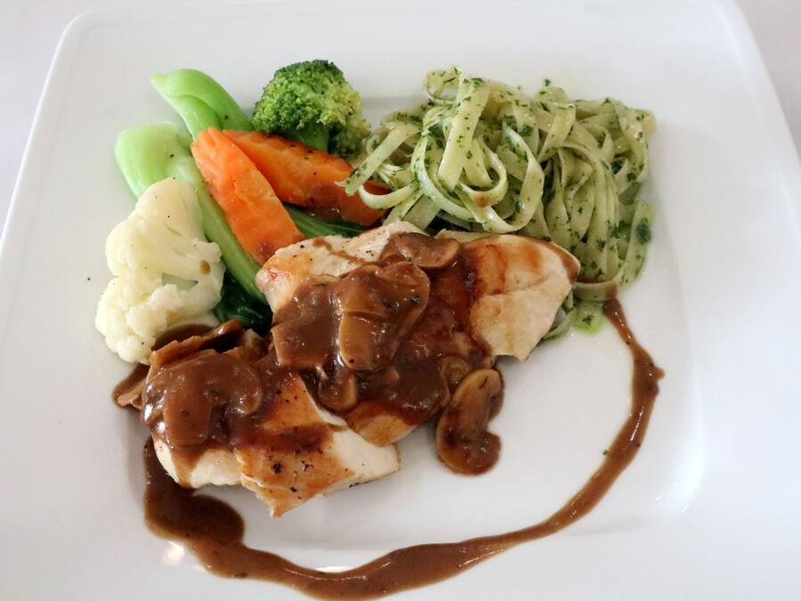 A plate with a piece of chicken, mashed potatoes, steamed vegetables, and pasta.