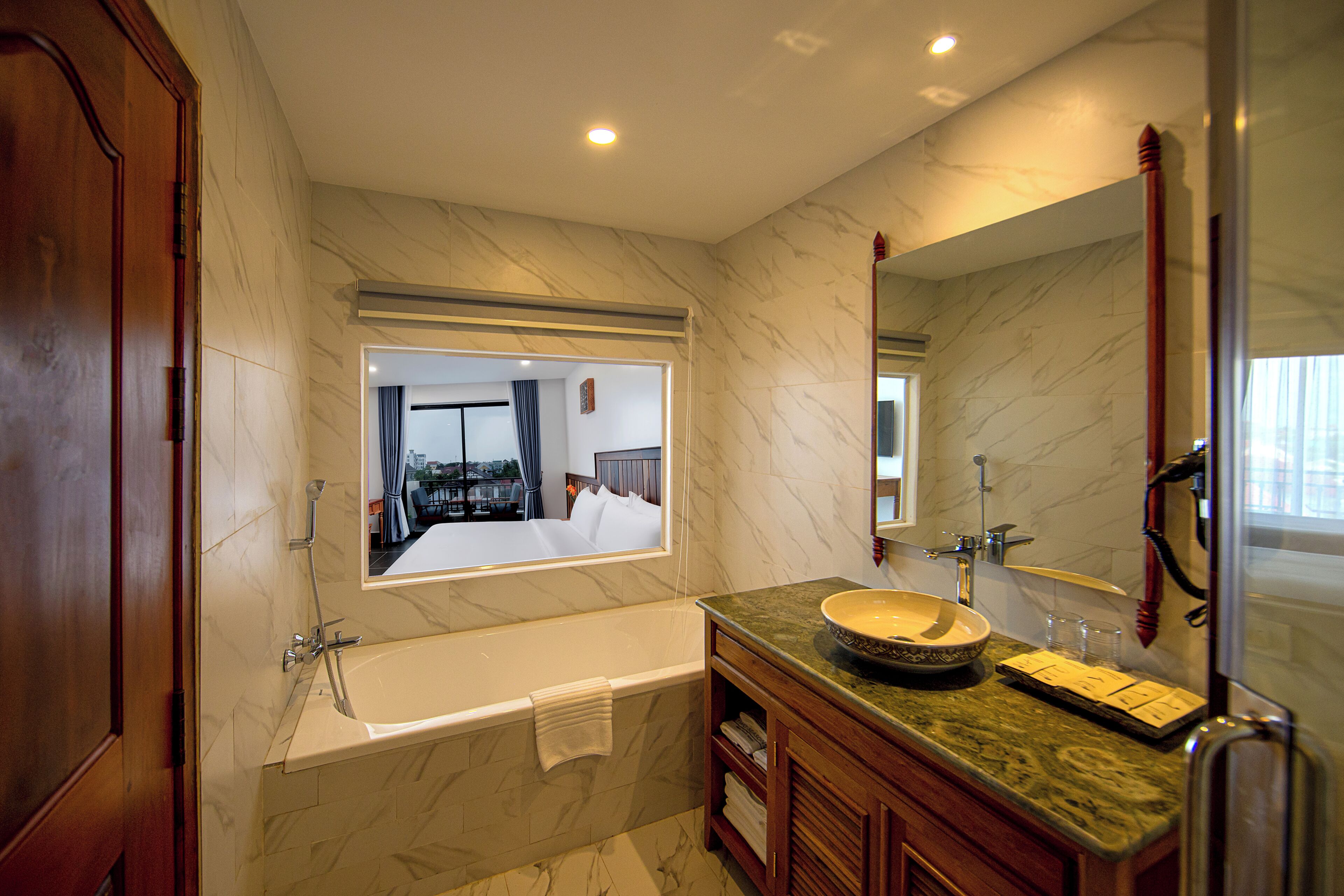 A modern bathroom with a bathtub, a large mirror, and a vanity with a bowl sink.