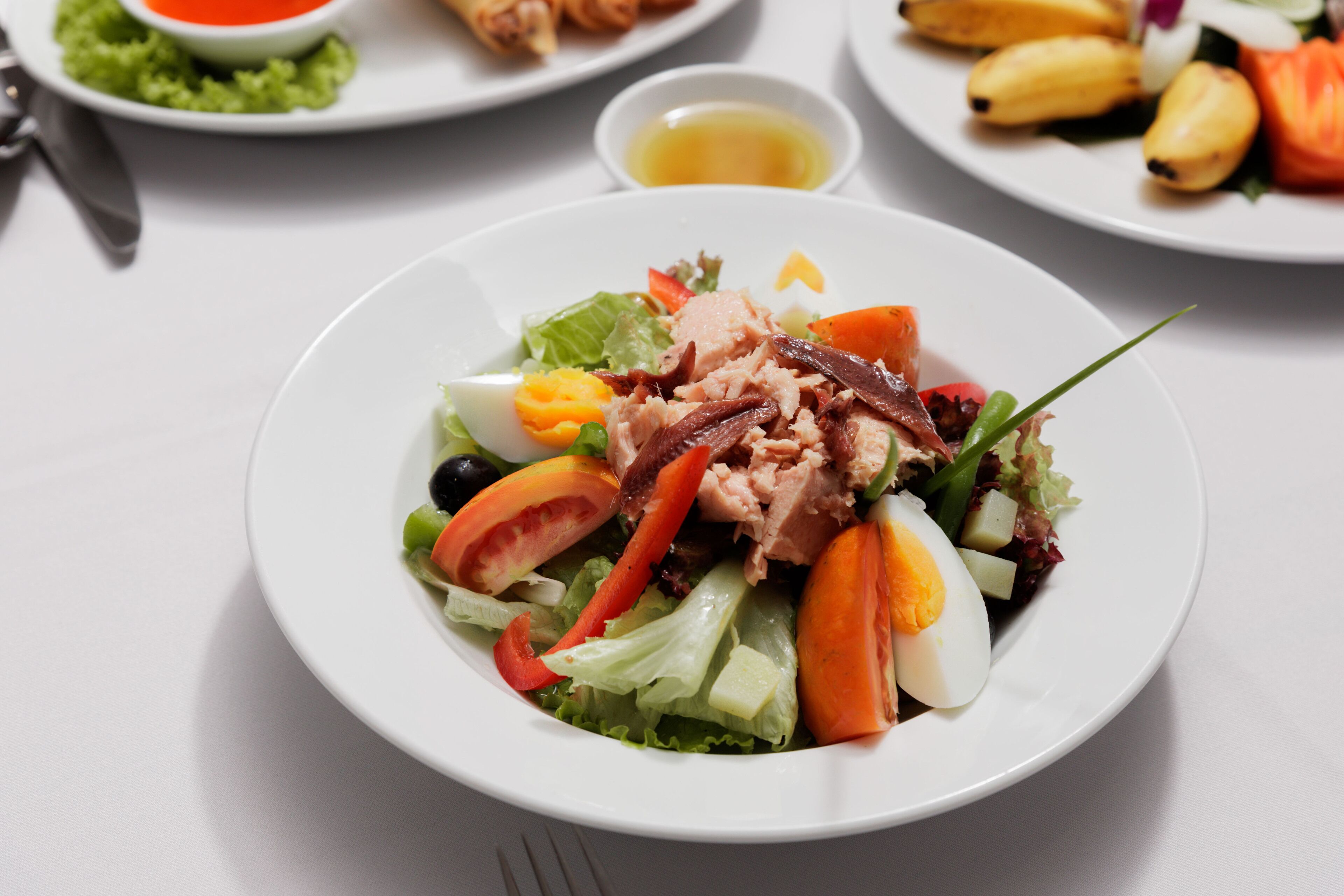 Une assiette de salade composée de divers légumes et d’un œuf dur.