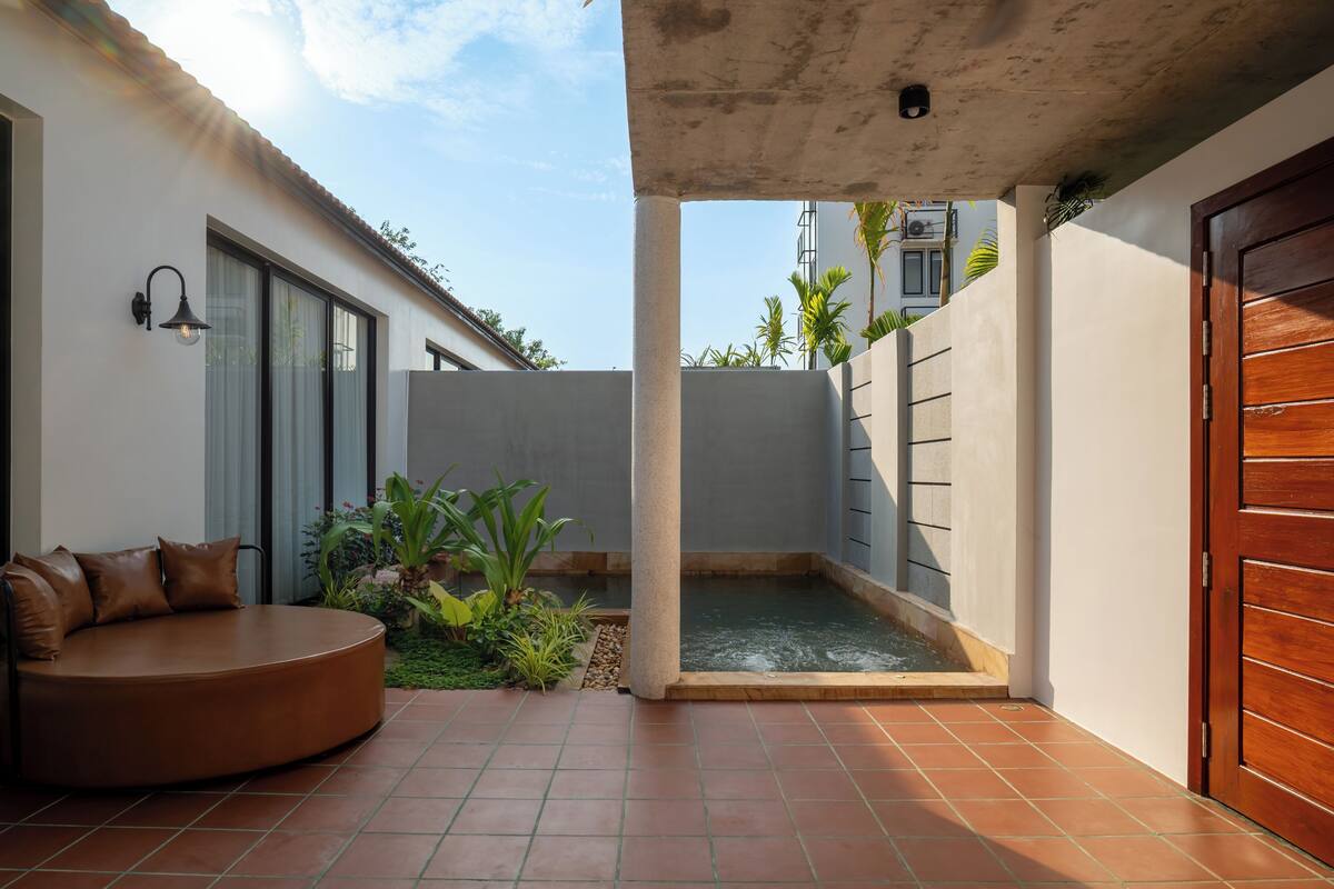 Une cour avec un espace de repos circulaire, une petite fontaine et une porte.