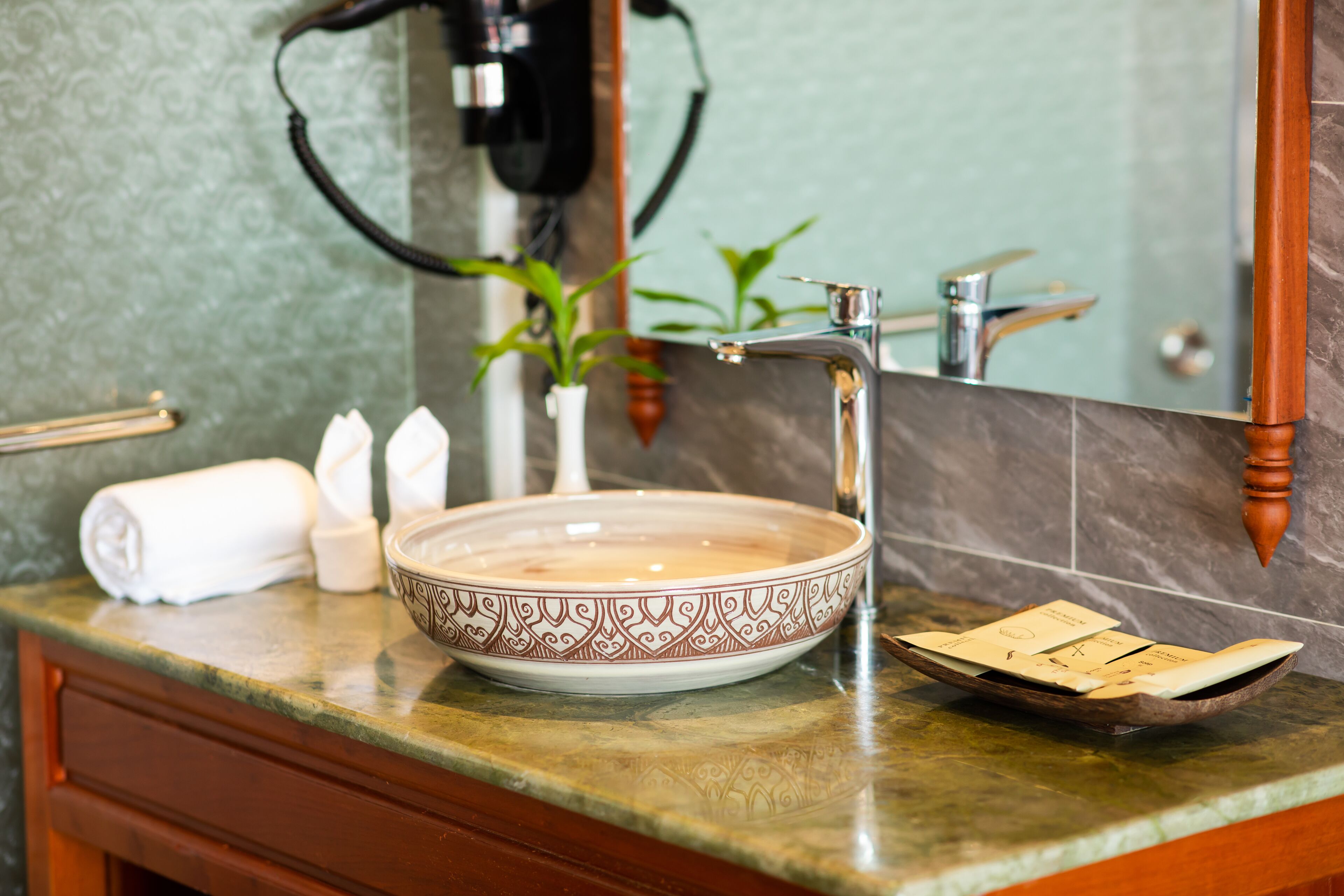 Un baño con encimera de mármol, un lavabo blanco, una toalla y un espejo.