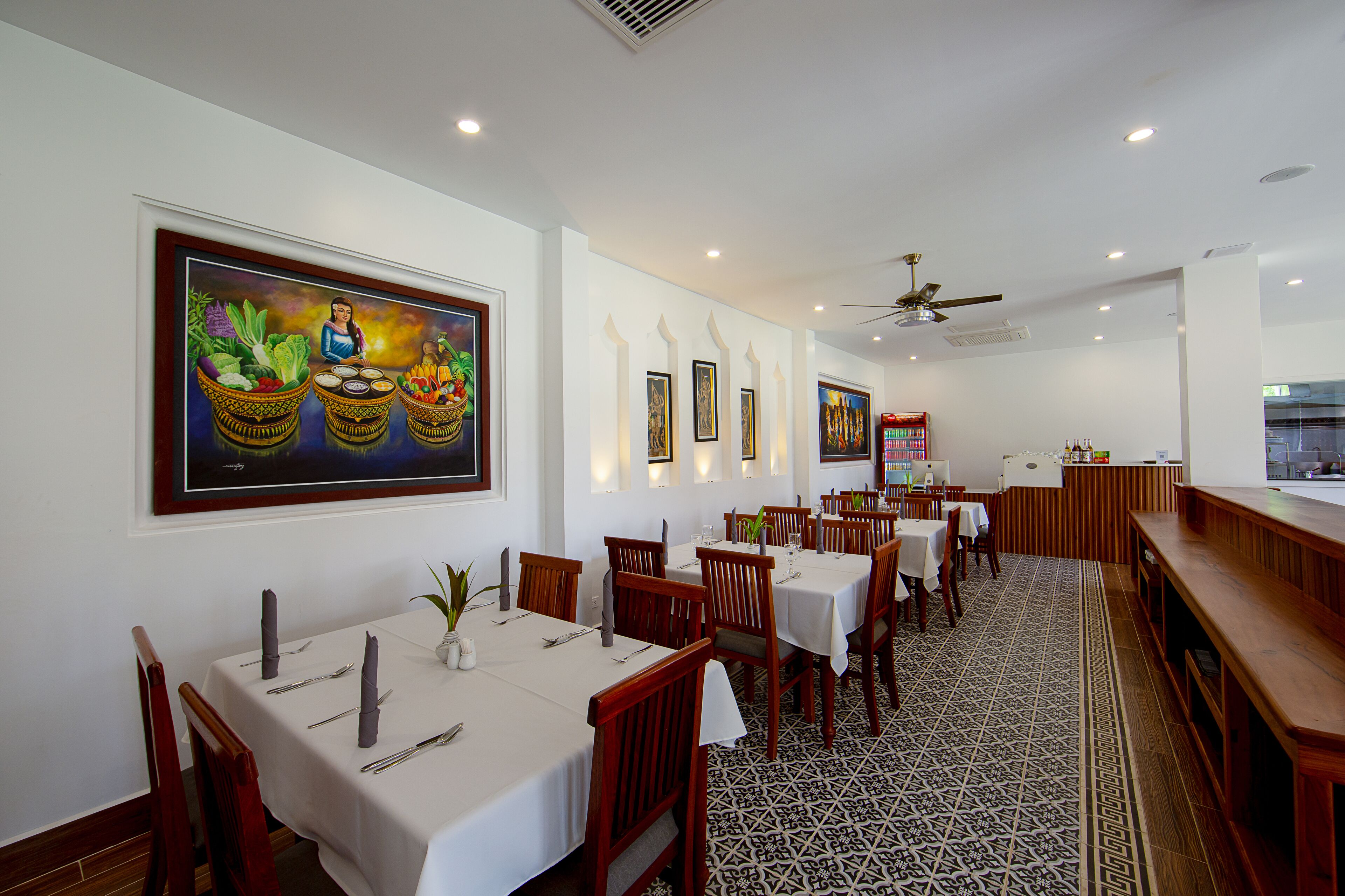A restaurant with multiple tables, chairs, and a patterned floor.