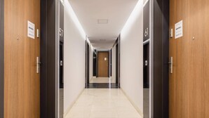 Un pasillo con puertas numeradas 57, 59 y 61, y un letrero que indica 'RENTERS'.