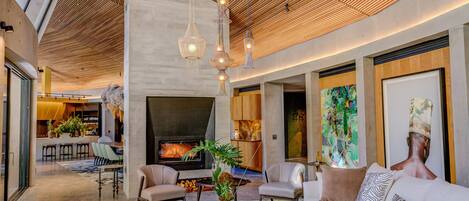 Una sala de estar moderna con chimenea, asientos cómodos y una mesa de centro.