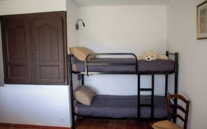 A bunk bed with a ladder, a wooden door, and a small chair.