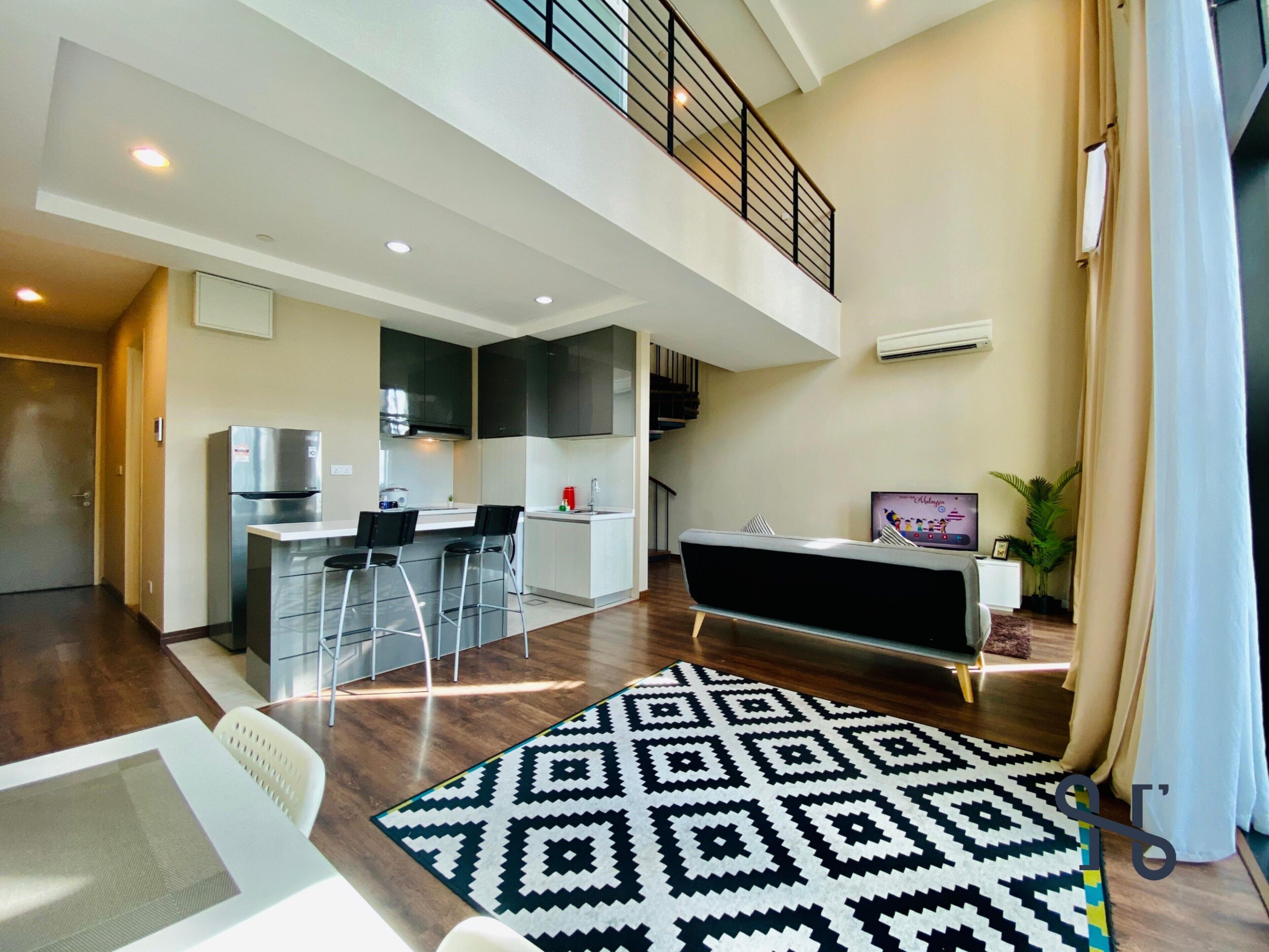 A modern apartment with a kitchen, dining area, and a living room with a patterned rug.