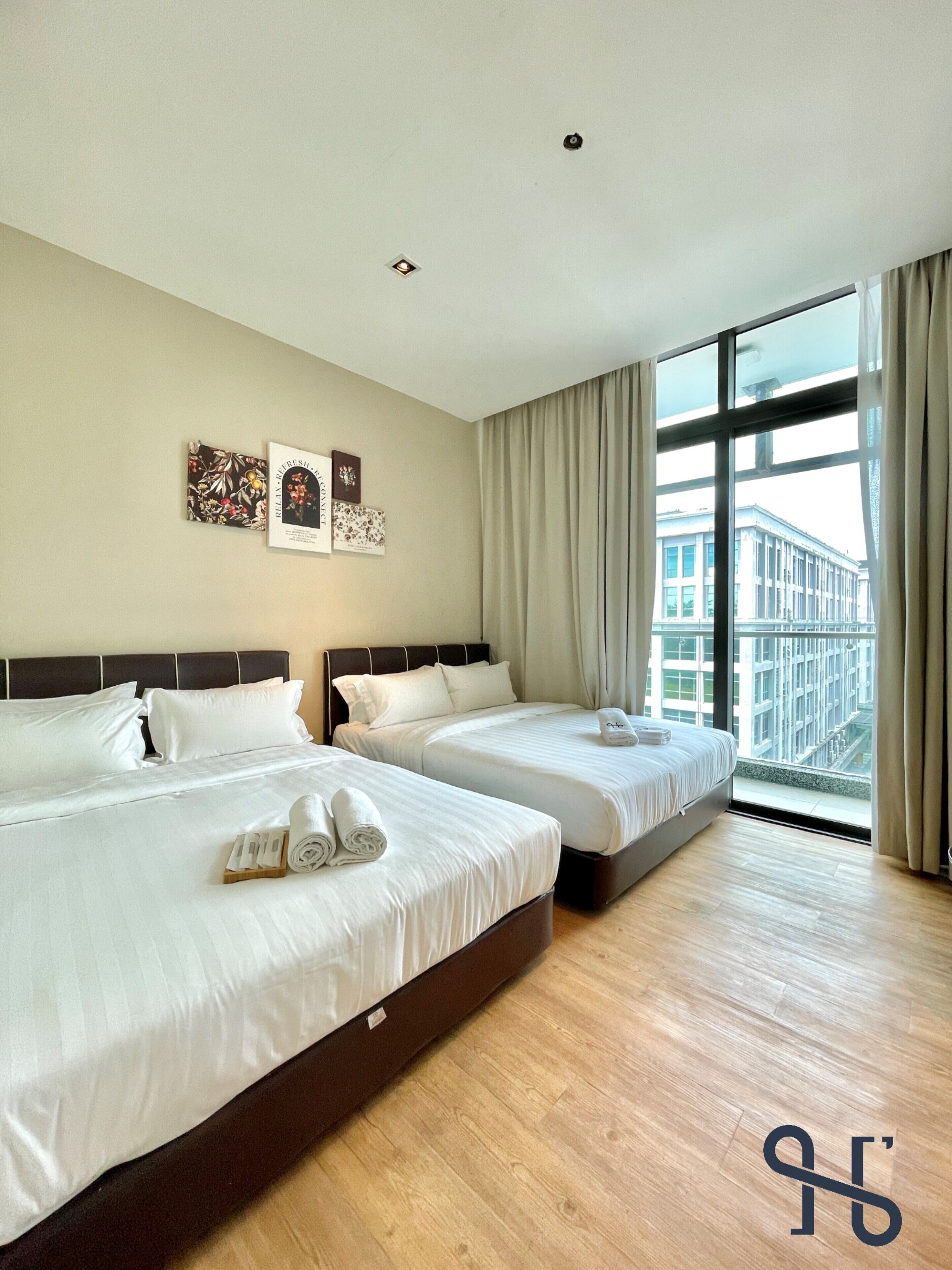 A hotel room with two beds, a large window, and artwork on the wall.