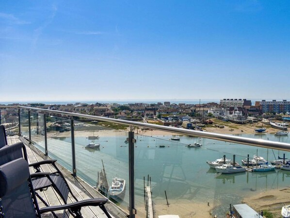 A balcony with a view of a marina and a coastal town.