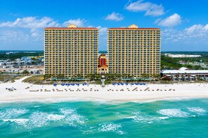 A beachfront hotel with two prominent buildings, a sandy beach, and ocean views.