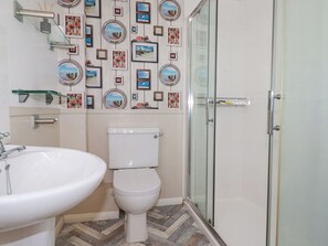 A bathroom with a toilet, sink, and shower. - 2 Old Talbot Cottages (Lostwithiel)