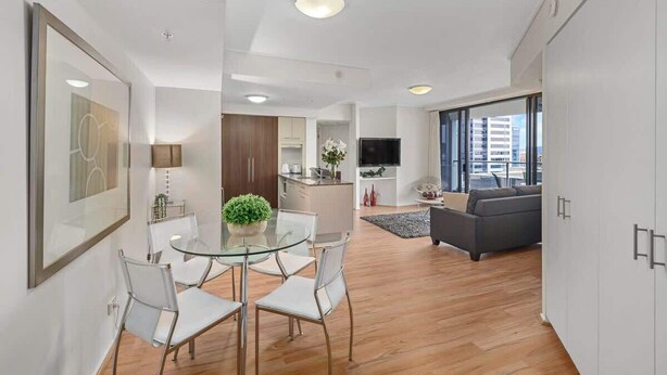 Un apartamento moderno con comedor, cocina, sala de estar y un gran ventanal con vistas a la ciudad.