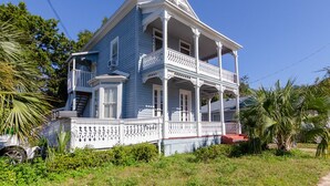 A two-story house with a balcony and a porch.