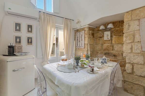 Enjoy meals in this cozy dining area with a dining table set for a meal, featuring tableware and a centerpiece.