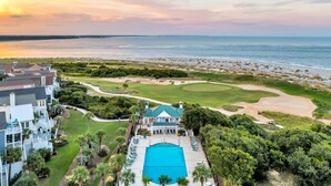 A resort with a large swimming pool, golf course, and beachfront views.