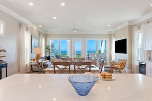 A spacious dining area with a large table, chairs, and a view of the ocean. - AMAZING Golf and Ocean View Home! Private Ocean Point Community! (Isle Of Palms)