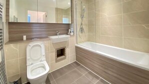 Un baño moderno con inodoro, lavamanos y bañera.
