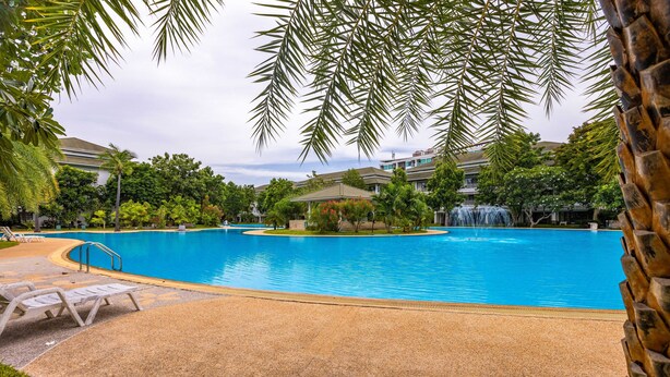 Piscina con sillones de descanso y una cascada.