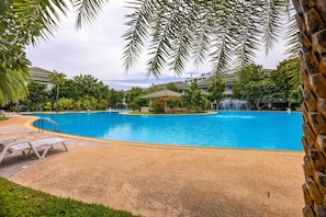 A swimming pool with lounge chairs and a waterfall feature. - 4 BR Townhouse in Great Location BSS (Hua Hin)