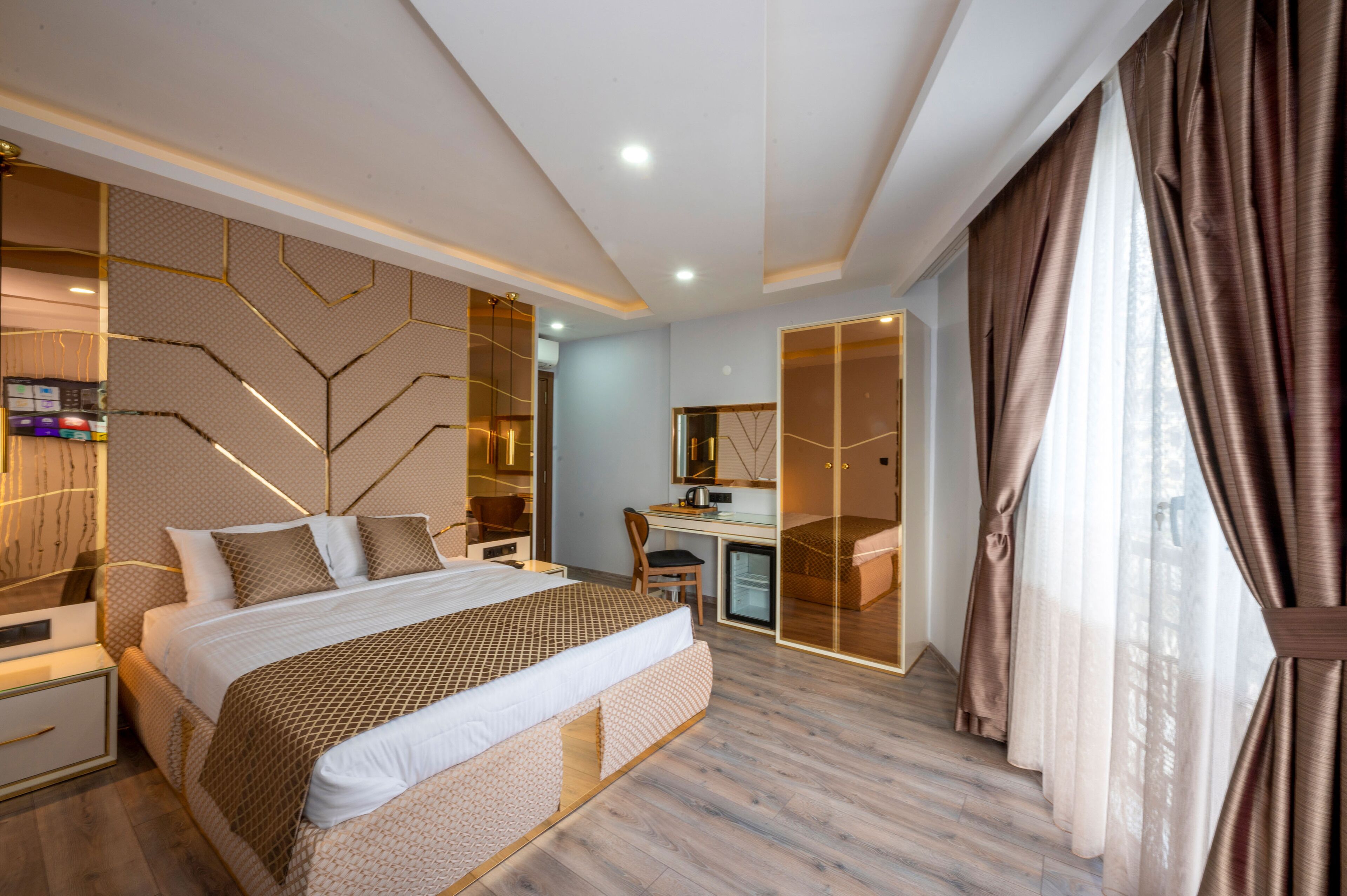 A modern hotel room with a large bed, a desk, and a walk-in closet.