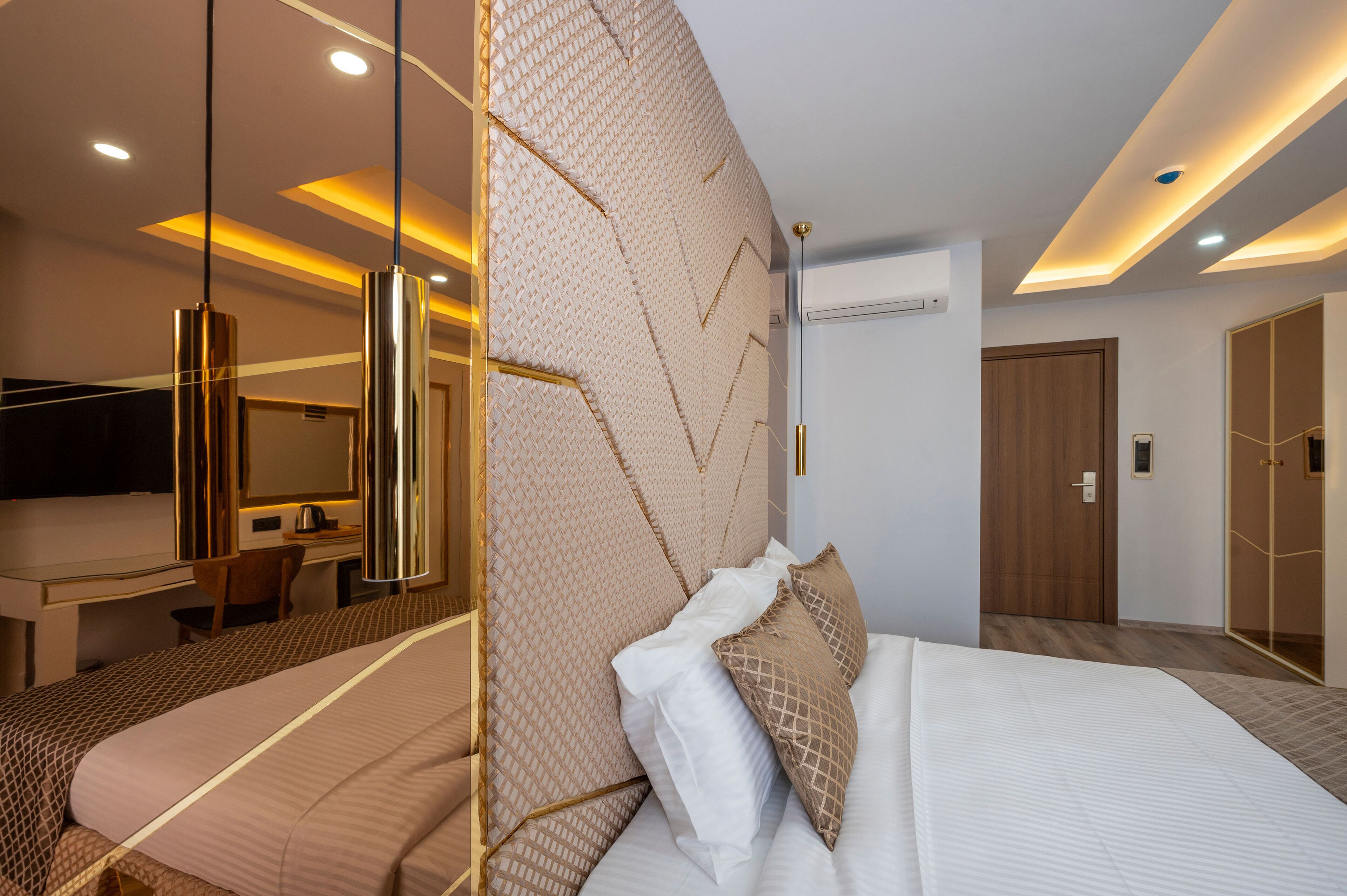 Una camera d'hotel moderna con un grande letto, una scrivania e uno specchio.