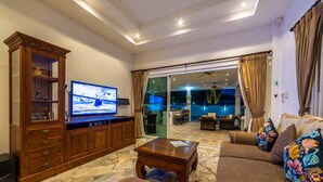 A living room with a television, wooden cabinet, sofa, and coffee table. - Private 3 Bedroom Pool Villa PP10 (Hua Hin)