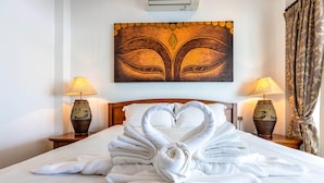 A hotel room with a bed, two lamps, a painting, and a curtain. - Private 3 Bedroom Pool Villa PP10 (Hua Hin)